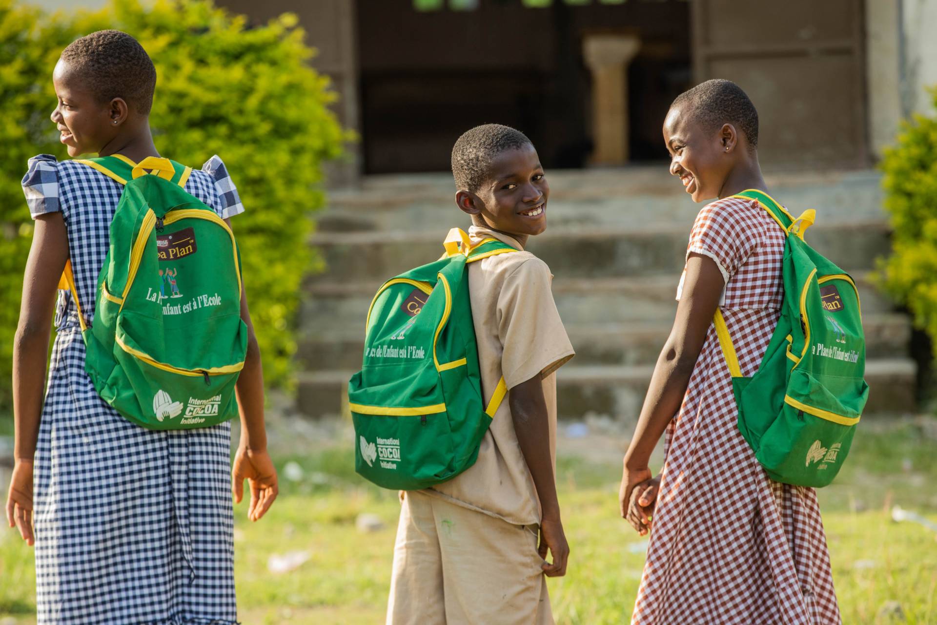 three kids wearing a nestle cocoa plan backpack